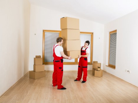 Moving staff wearing PPE while lifting furniture safely